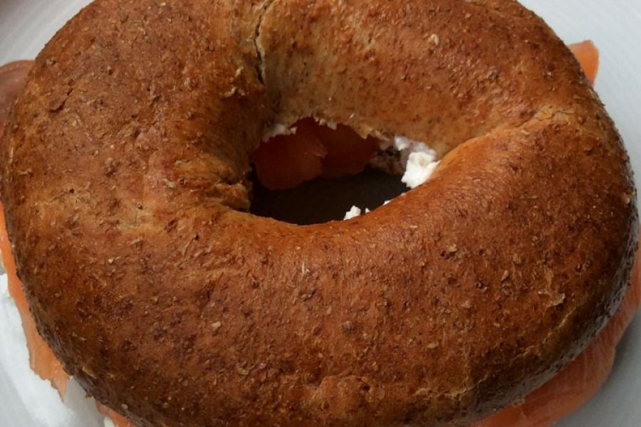 Bagel de harina integral con salmón ahumado y queso crema.
