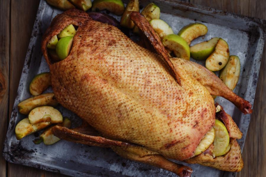 Pato asado con manzanas en una fuente de horno.