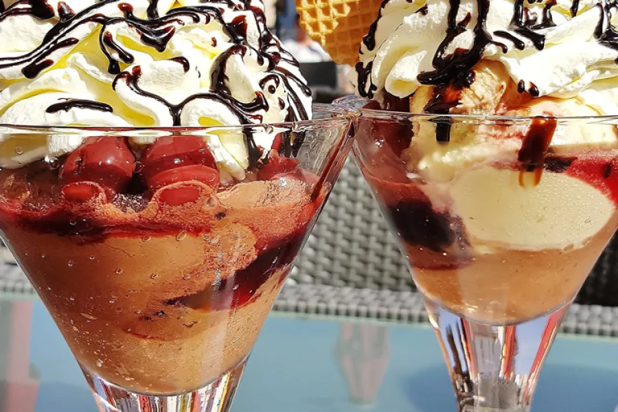 Dos copas con mousse de chocolate y cerezas decorado con nata montada.