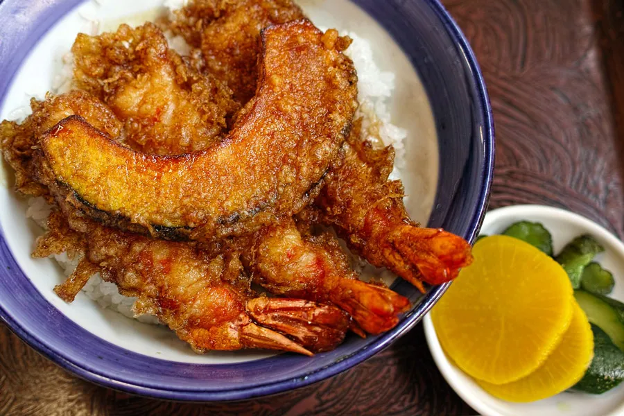 Tempura con gambas y calabaza en un cuenco.