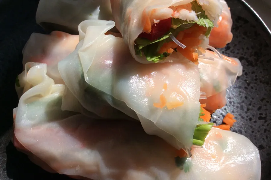 Detalle de rollitos vietnamitas rellenos de ensalada y gambas cocidas.
