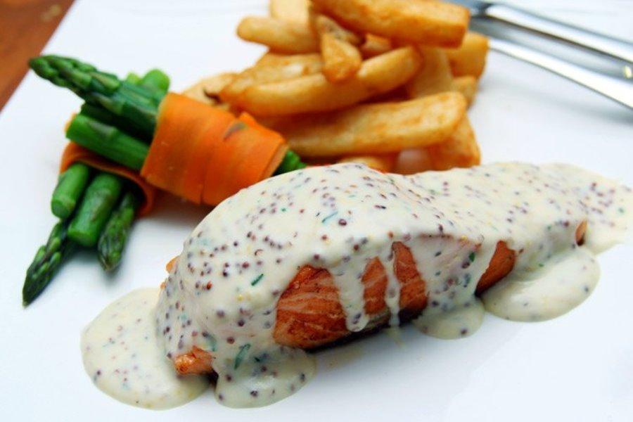 Salmón a la parrilla con salsa de mostaza en grano.