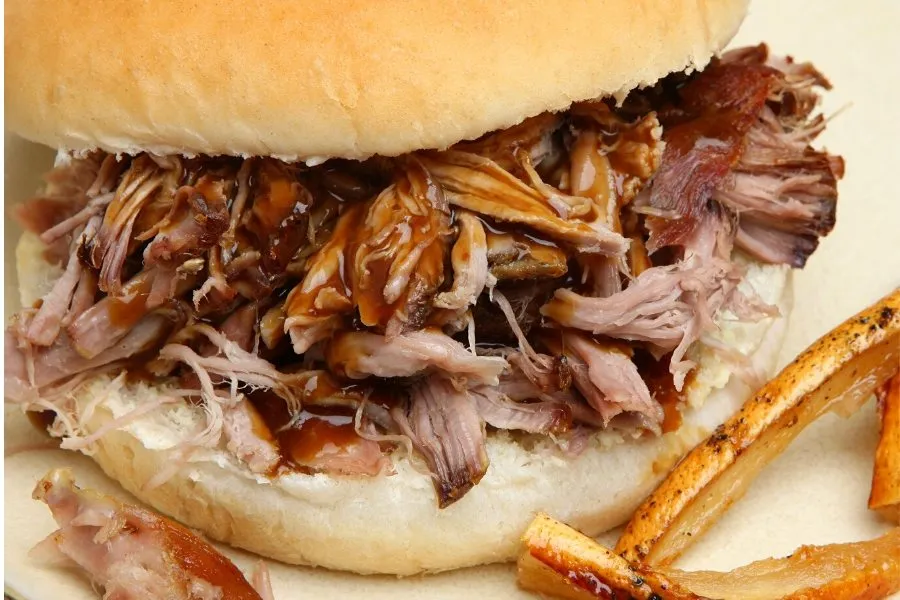 Bocadillo de carne de cerdo asada con salsa barbacoa.
