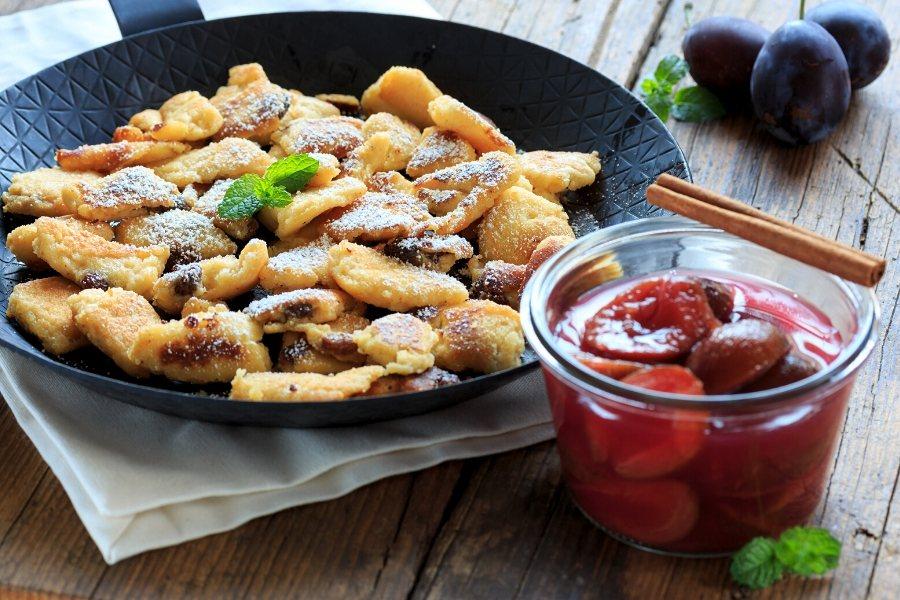 Kaiserschmarrn en sartén acompañado de compota de ciruelas.