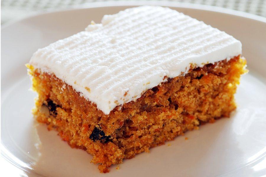 Un trozo de bizcocho de plátano y zanahoria con glaseado dulce.