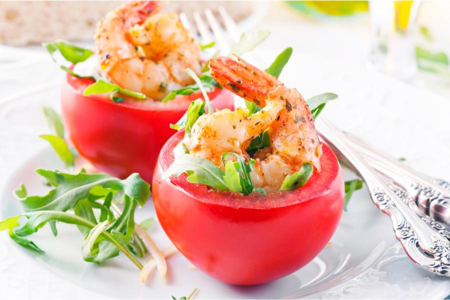 Tomates rellenos de cangrejo decorados con colas de gamba.