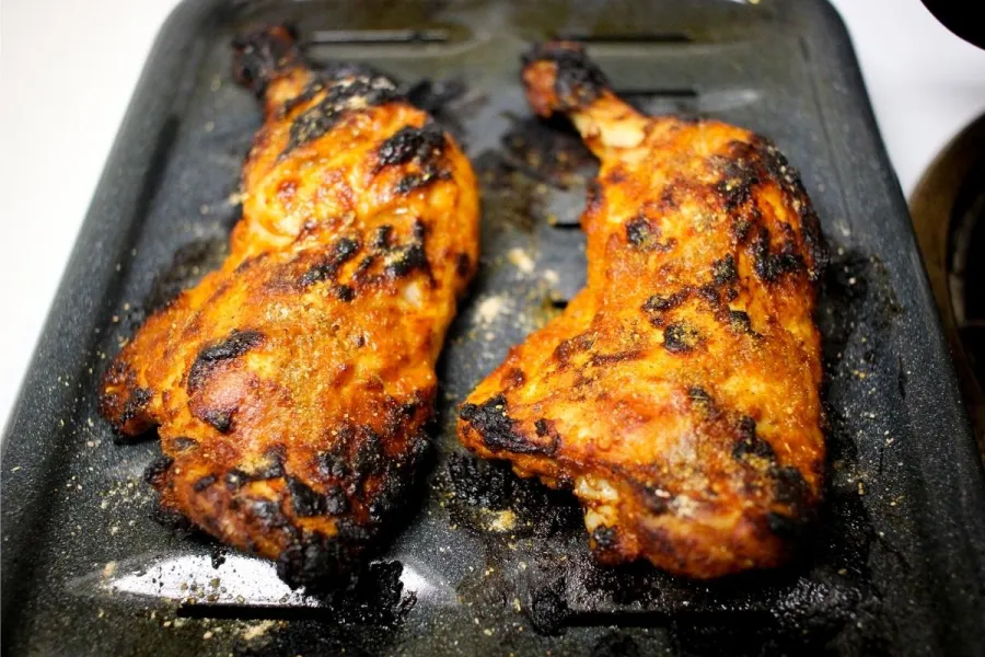 Patas de pollo tanduri en una bandeja de horno.