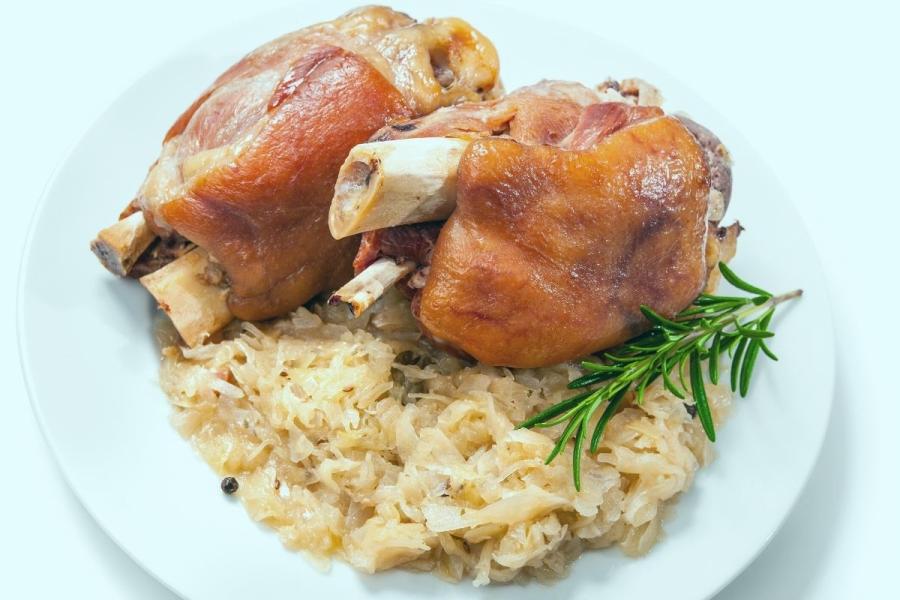 Codillos de cerdo al estilo alemán en un plato con chucrut.