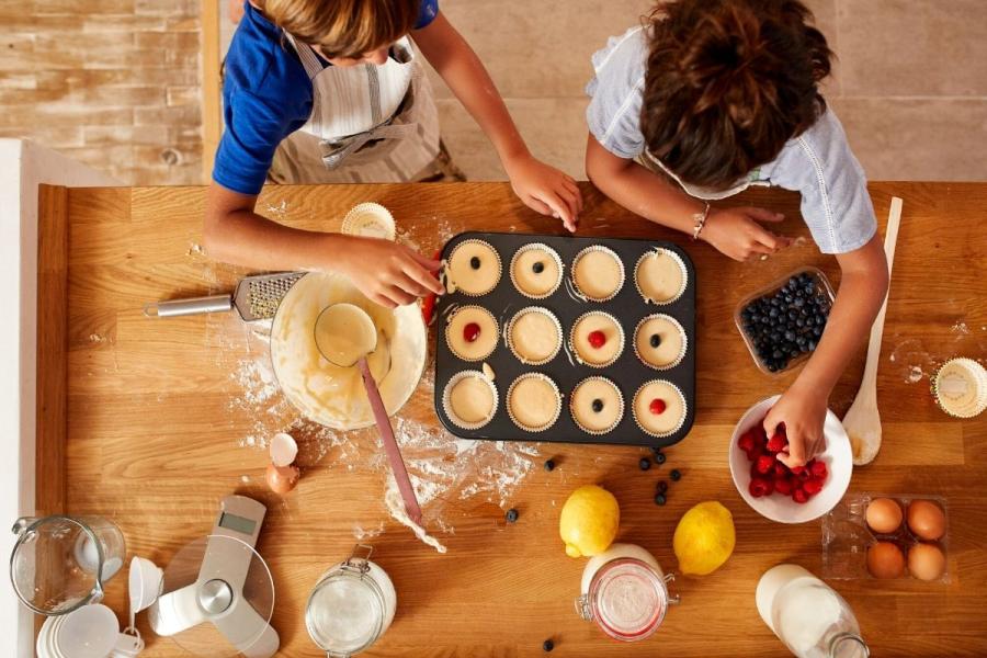 NIños preparando una bandeja de bizcochitos para el horno.