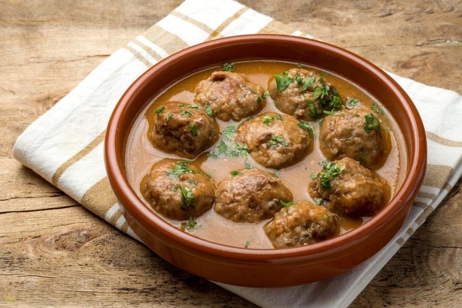 Una cazuela de barro con albóndigas en salsa.