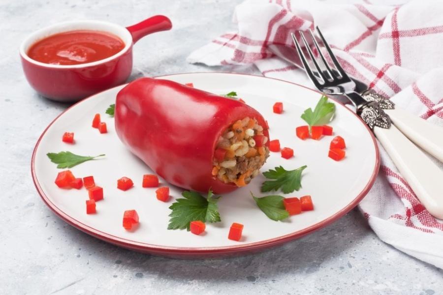 Un plato con un pimiento relleno decorado con cuadraditos de pimiento.