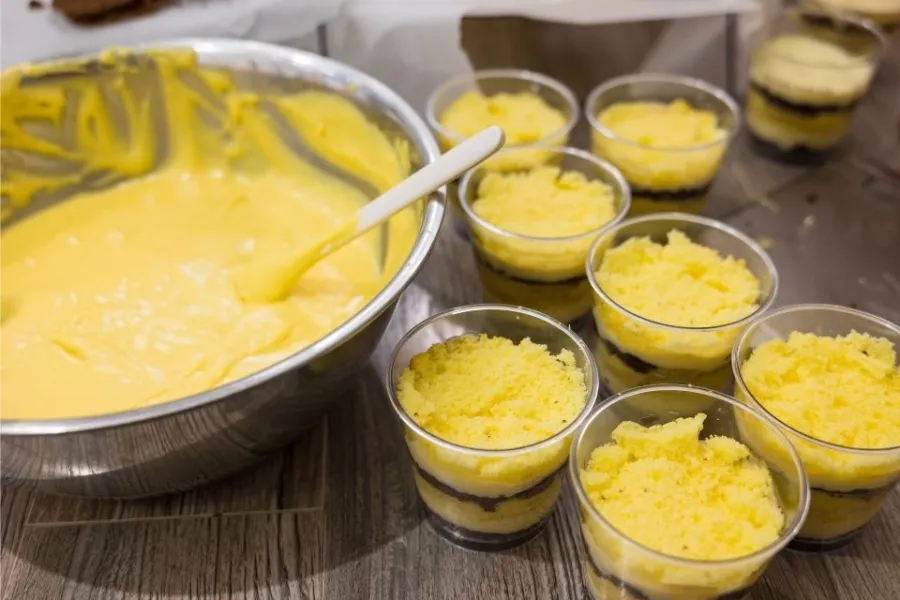 Repartiendo crema helada de coco y mango entre recipientes individuales.