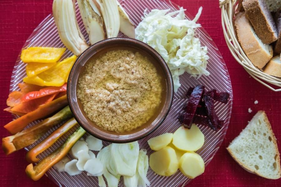 Un cuneco con salsa bagna càuda rodedado de verduras y hortalizas.