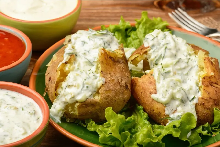 Una patata asada cubierta con tzatziki.