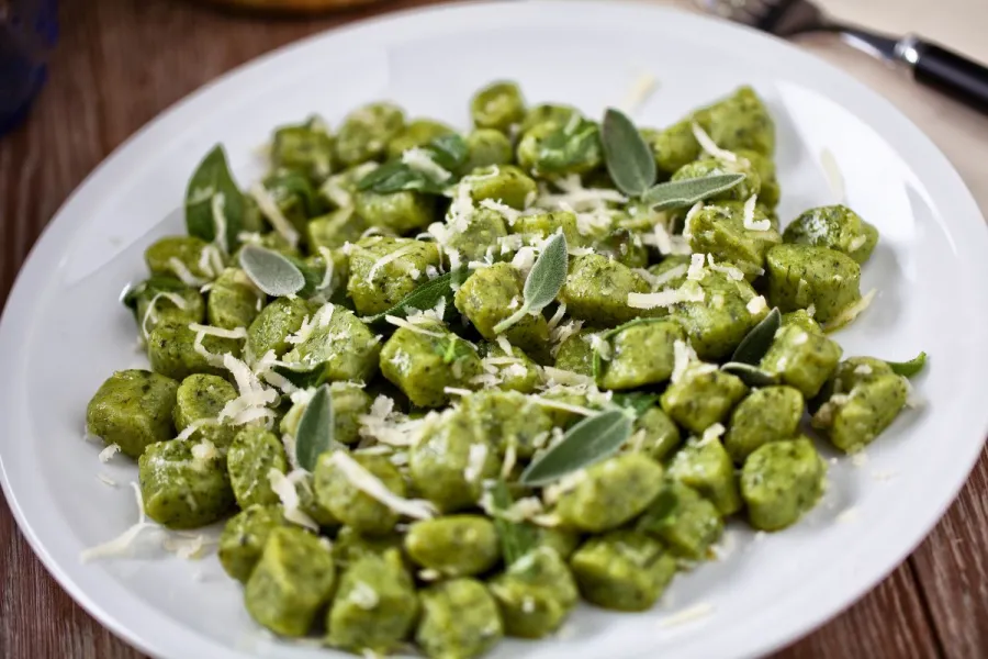 Ñoquis de espinacas con salvia y queso rallado.