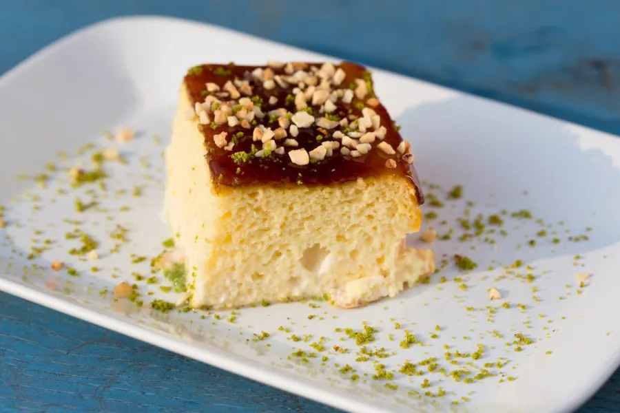 Un trozo de pastel de tres leches decorado con pistacho picado.