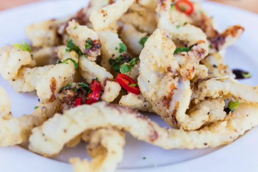 Calamares fritos con sal y pimenta de limón con cilantro fresco y chile tailandés.