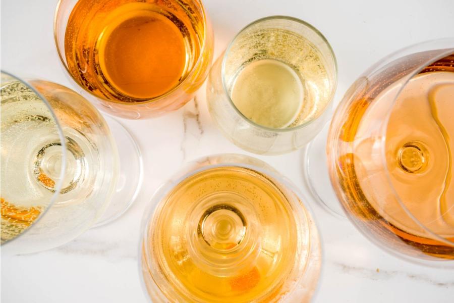 Varias copas con vino naranja de diferentes tonos.