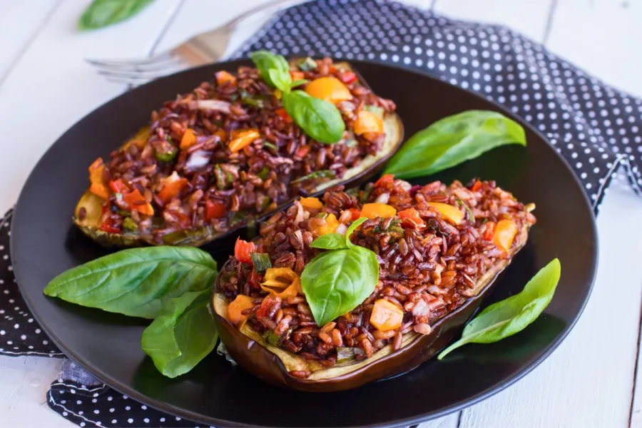 Berenjenas rellenas de arroz rojo y verduras, sin queso rallado.