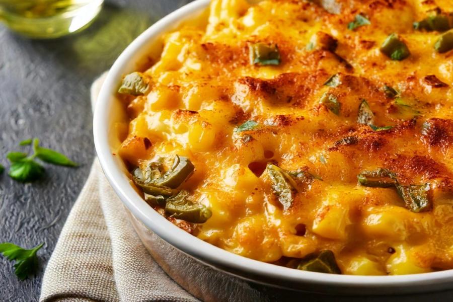 Detalle de un budín de macarrones con queso al que se le ha añadido pimiento verde.