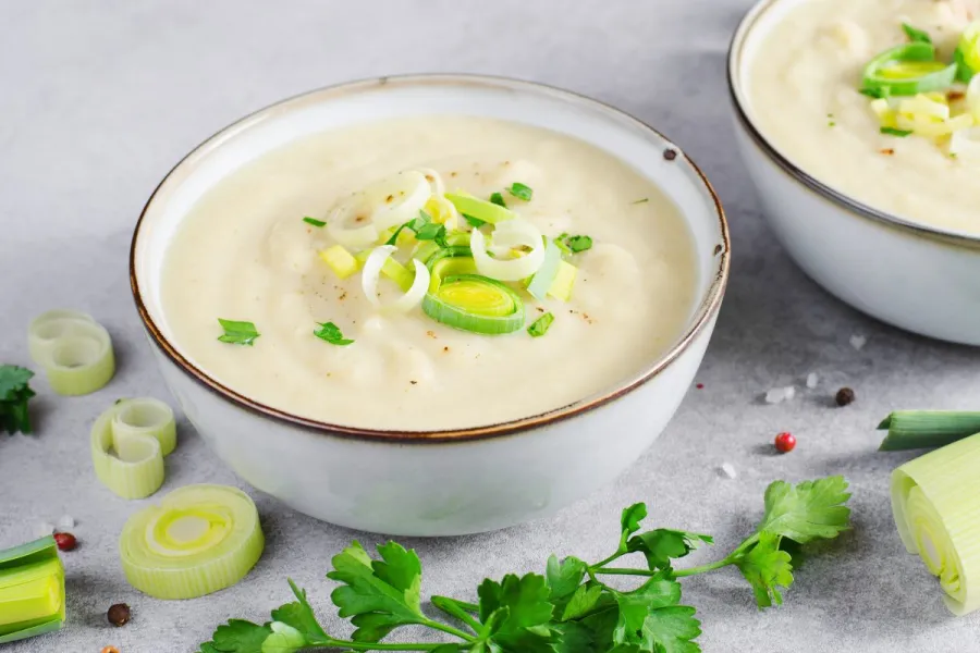 Un cuenco de potage parmentier decorado con tiras de piuerro.
