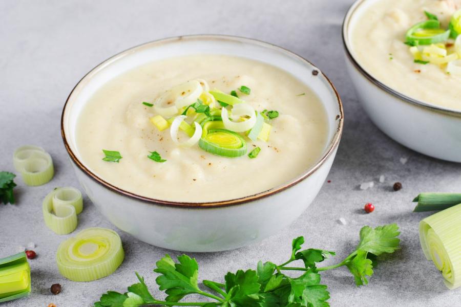 Un cuenco de potage parmentier decorado con tiras de piuerro.