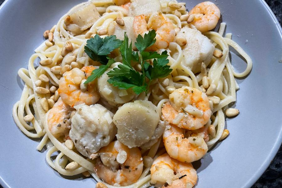 Un plato de pasta Freeport decorado con piñones tostados y perejil.