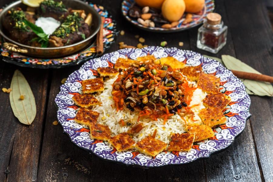 Una fuente de arroz enjoyado decorado con trozos de la costra, o tahdig, alrededor.