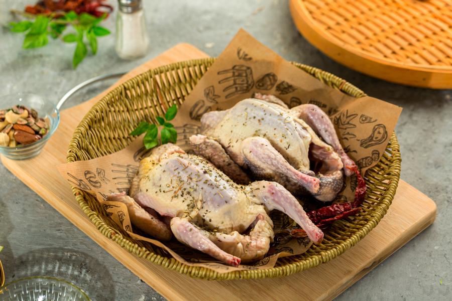 Dos pichones crudos, sazonados y listos para cocinarlos.