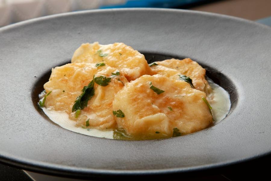 Un plato hondo gris con patatas a la importancia, una presentación elegante.