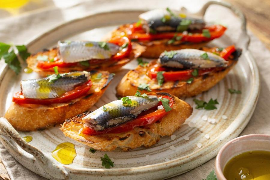 Varios crostini caseros de sardinas y pimientos del piquillo, servidos como aperitivo elegante.