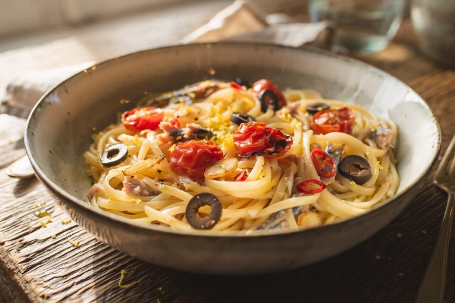 Un plato de pasta mediterránea picante con sardinas, estilo fusión casera.