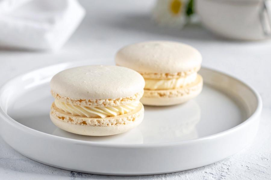 Dos macarons rellenos de crema de coco en un plato.