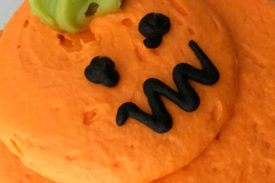 Biacochito de vainilla decorado como calabaza terrorífica.