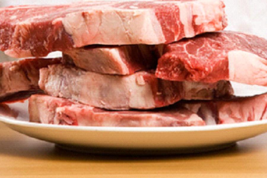 Cuatro filetes de carne en un plato blanco de loza.