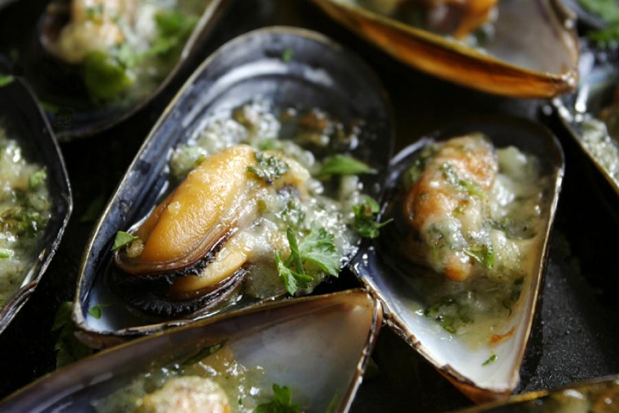 Detalle de mejillones con salsa de ajo y perejil.
