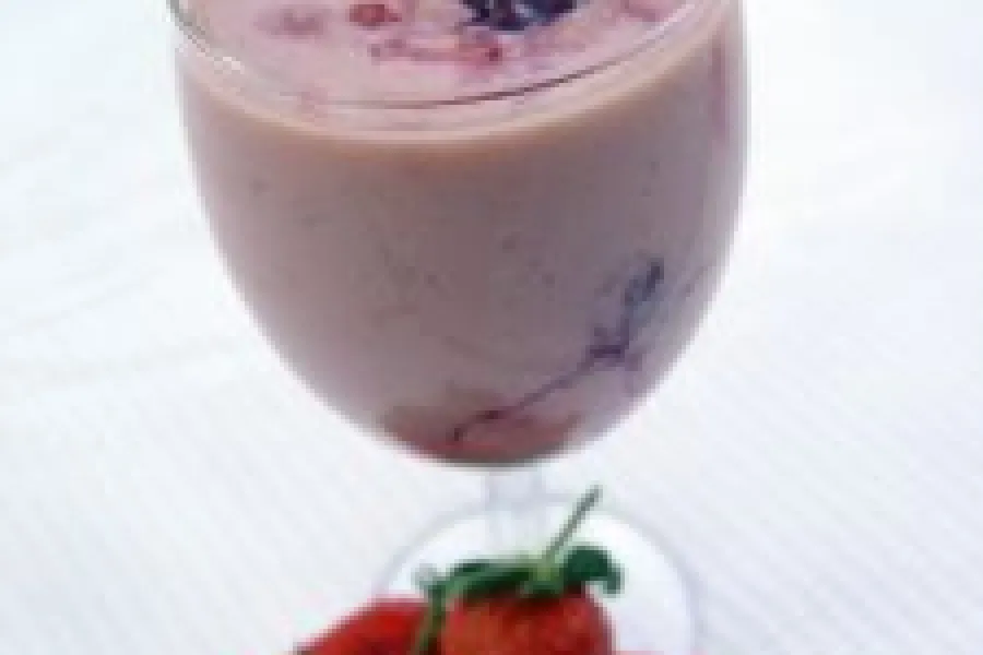 Batido de fresa servido en copa y decorado con fruta fresca.