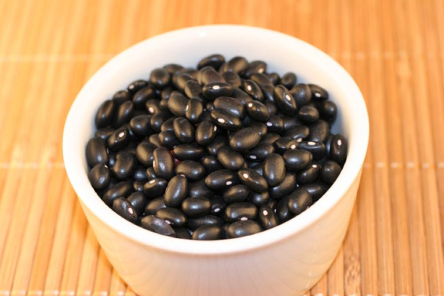 Frijoles negros en un cuenco de loza blanca.