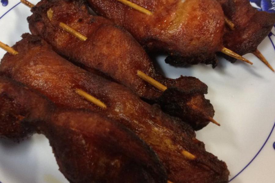 Varios pinchos de pollo teriyaki, ya cocinados, en un plato.