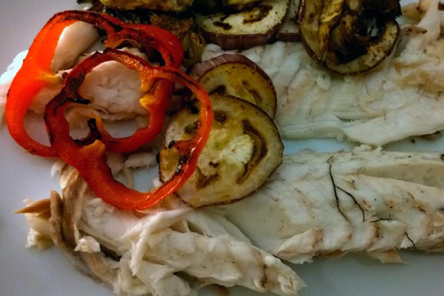 Pescado hecho a la sal servido en el plato con verduras a la plancha.