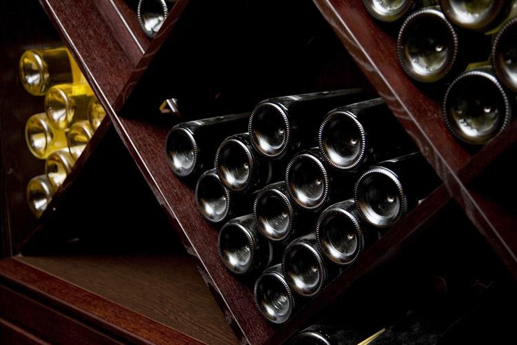 Botellas de vino en estanterías romboidales.