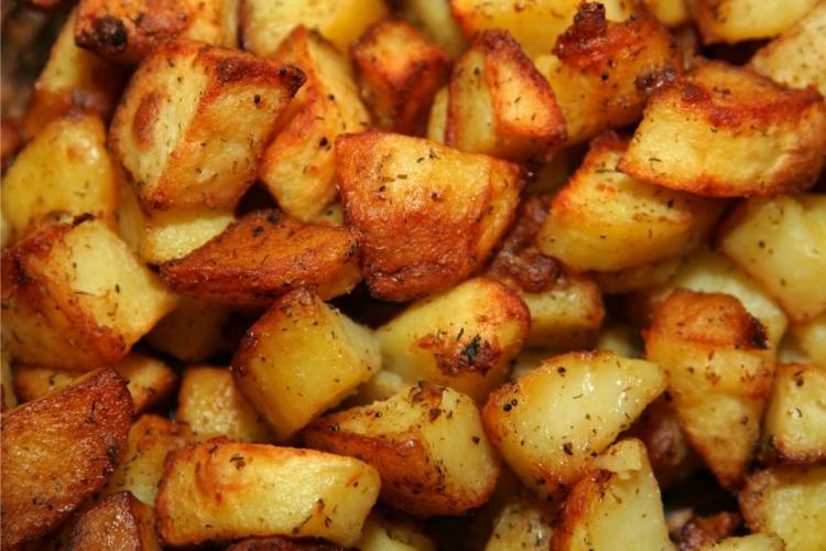 Detalle de patatas troceadas y asadas como guarnición.