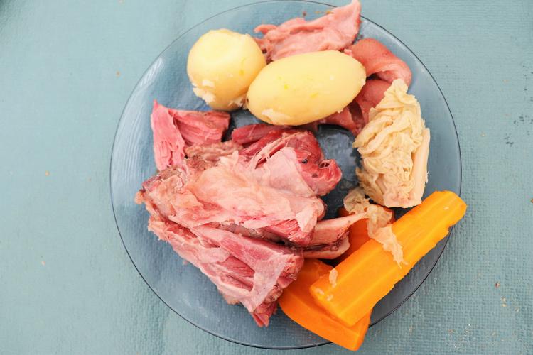 Un plato de cocido alemán con carne de cerdo, patatas, repollo y zanahoria.